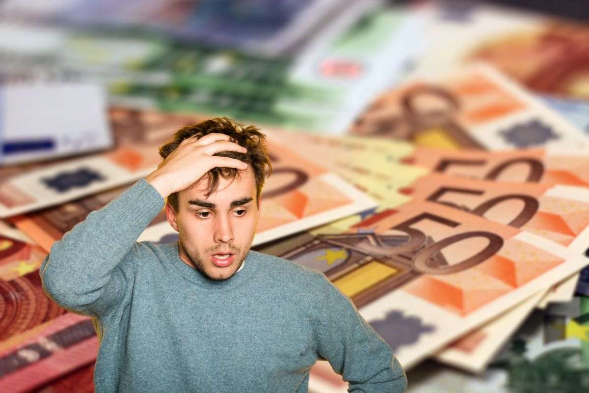 sfondo di tante banconote e uomo preoccupato con le mani tra i capelli