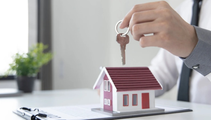 casetta in miniatura e persona con in mano delle chiavi