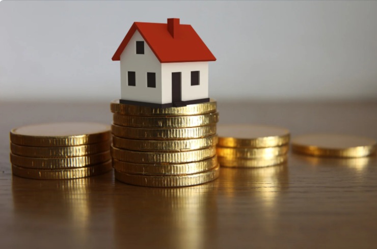 casetta in miniatura sopra una pila di monete