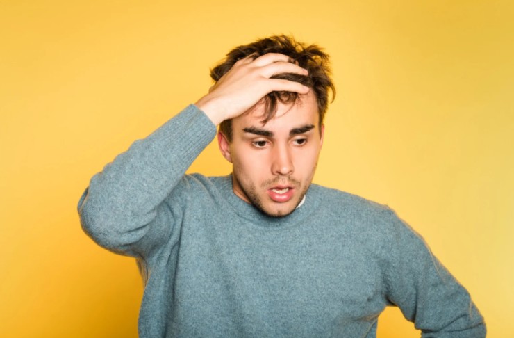 uomo preoccupato con una mano sulla fronte