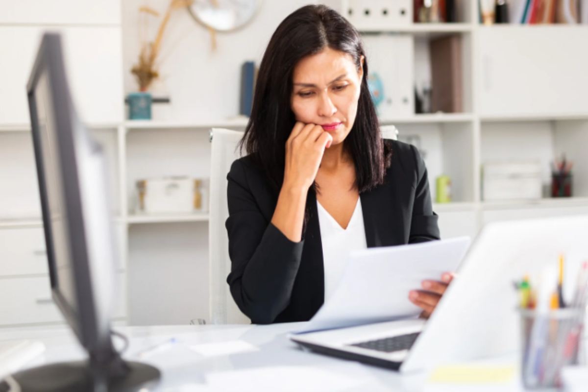 donna che legge dei fogli con espressione preoccupata