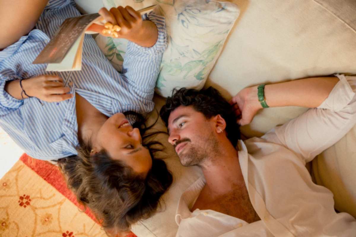 uomo e donna stesi sul divano faccia contro faccia